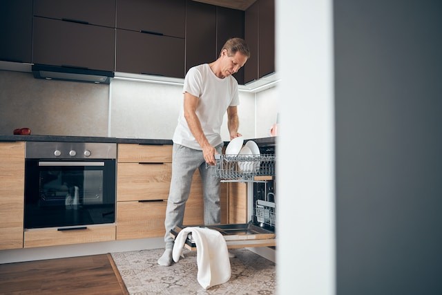 man taking dishes out of the dishwasher