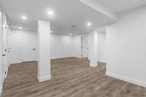 Basement Room - an empty room with white walls and wooden floors